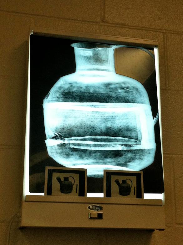 An x-ray of a watering can reveals a design on the object.