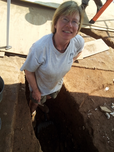Field director Laura Galke examines a Colonial-era cellar feature.